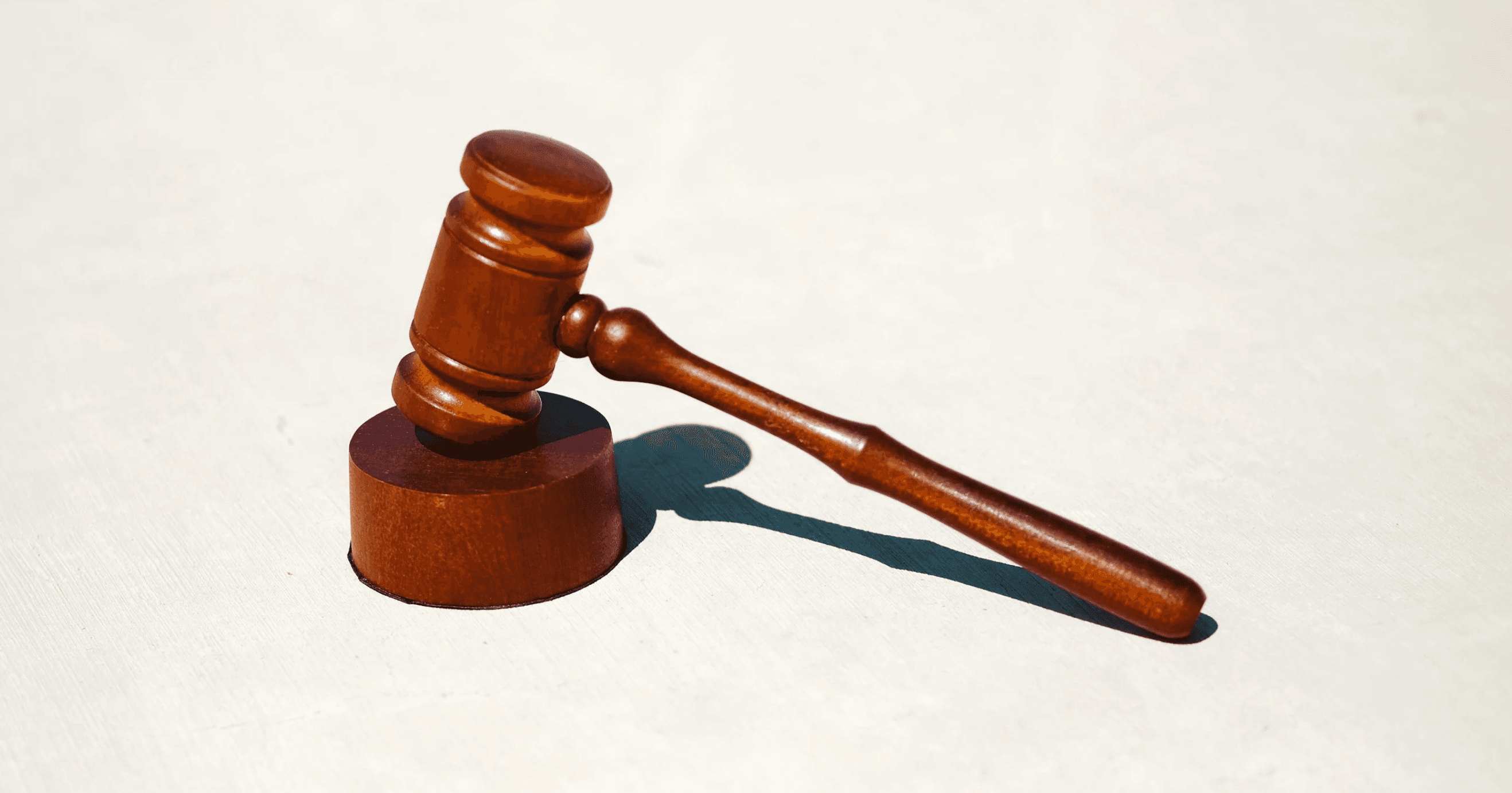 A wooden judge's gavel resting on its sound block